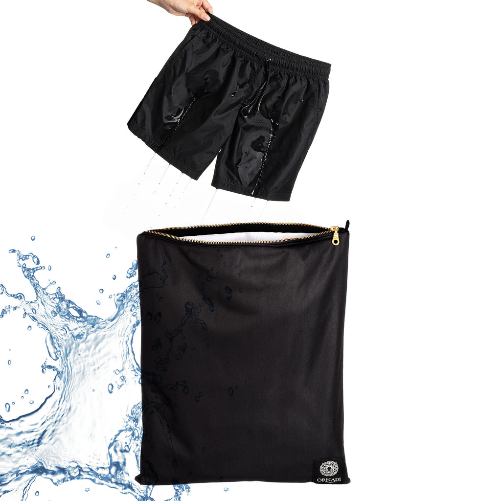 Black wet swimsuit being placed into a black Ornadi waterproof swimsuit  bag with water splashing around.